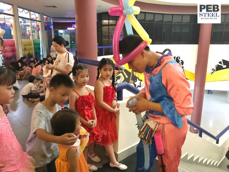 Clown making cute balloons for children at PEB Steel party