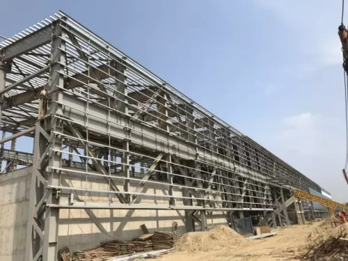 The steel frame structure comprises upright steel columns, horizontal steel beams, and steel connections that help assemble the components.